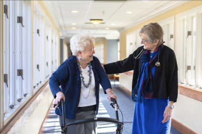 Senior woman walking with caregiver